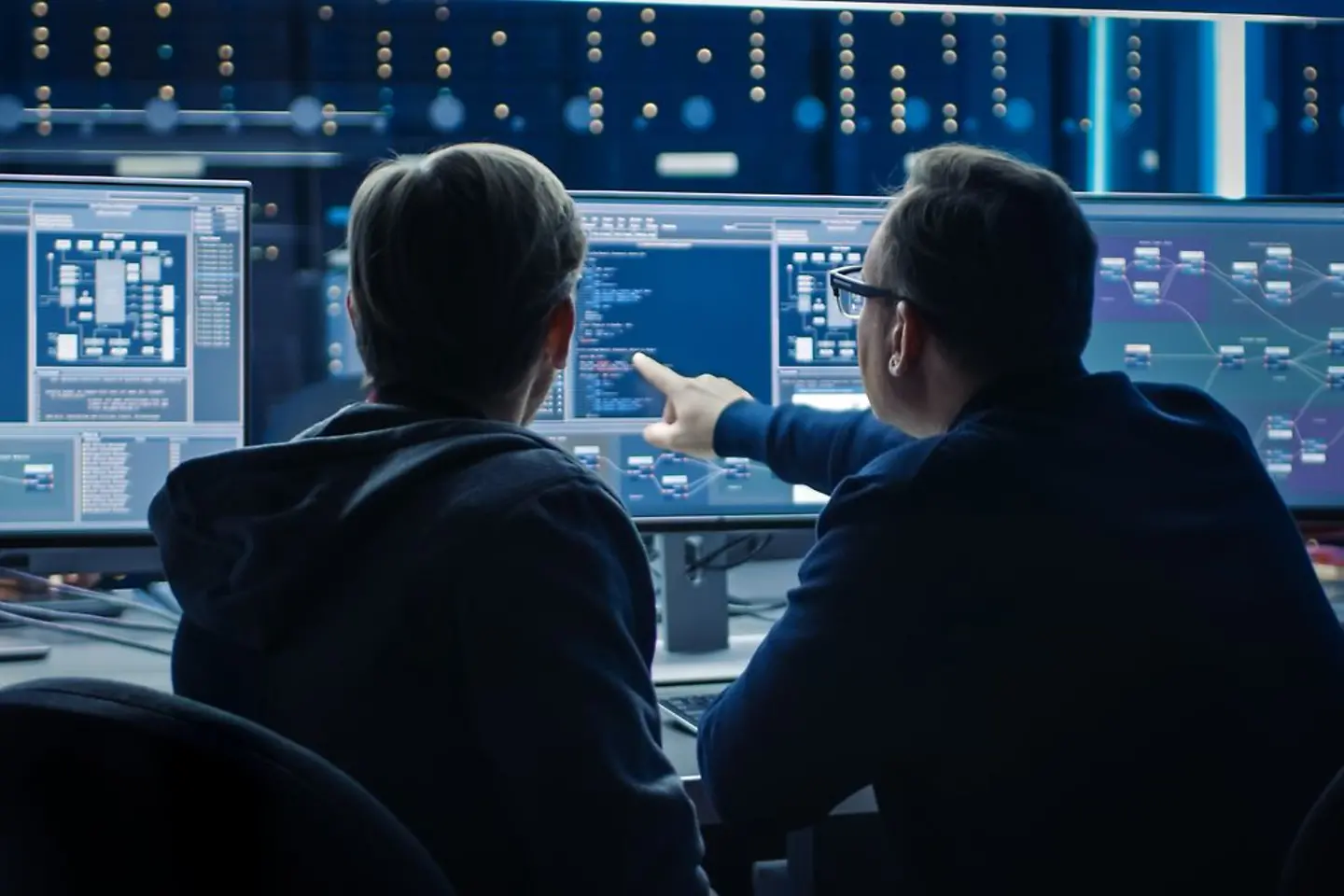 Two software professionals looking at data anaylsis on computer screen
