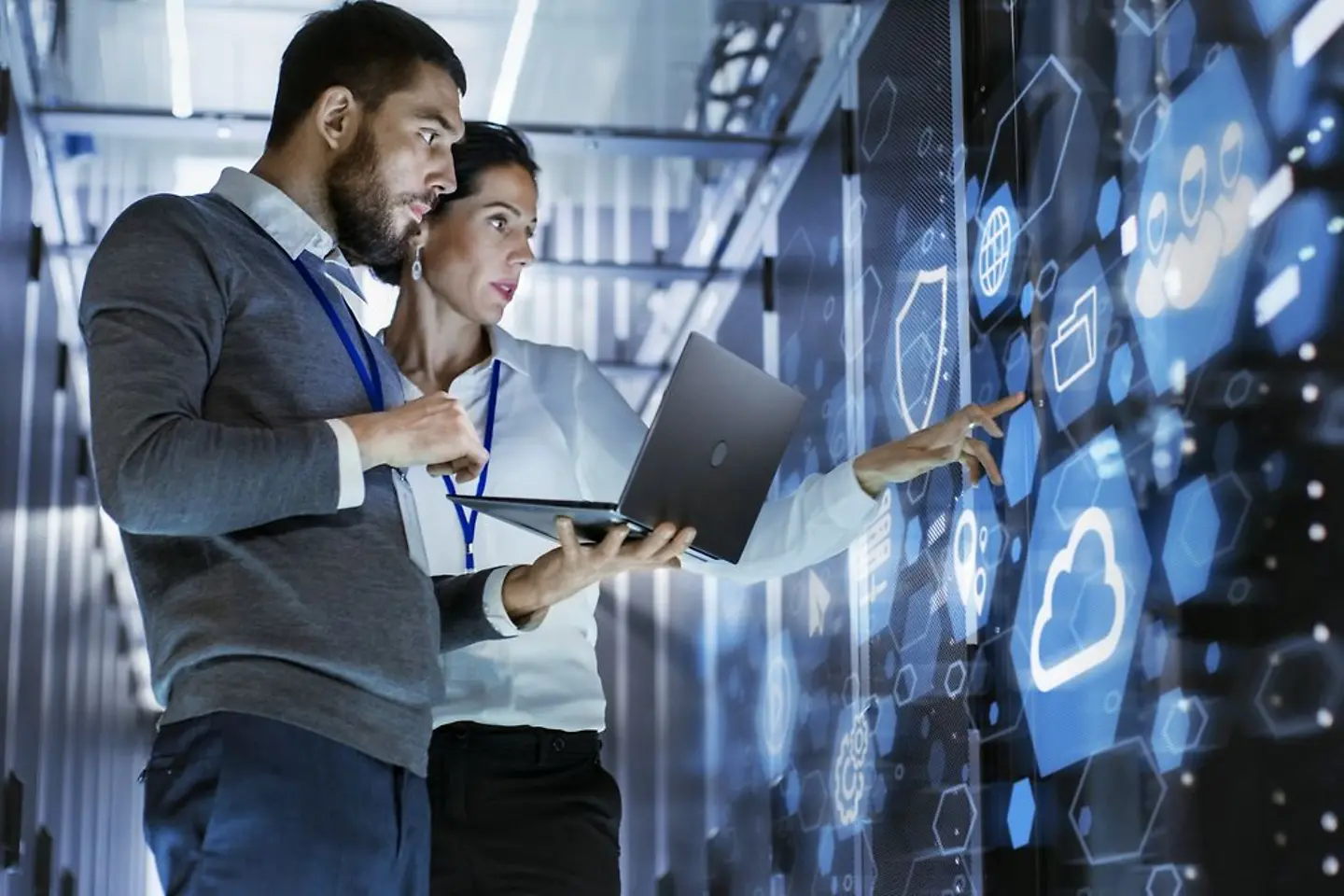 Dois especialistas em software trabalham em uma sala de servidores de dados