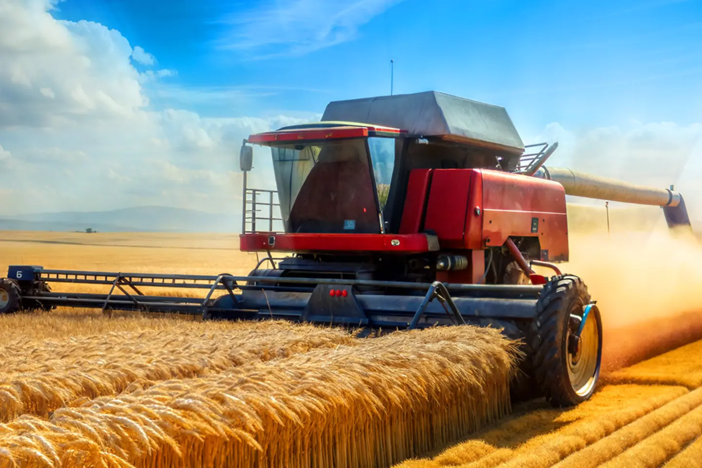 AI-generated image - a wheat field with a combine harvester on the left with a large expanse of clear sky 
